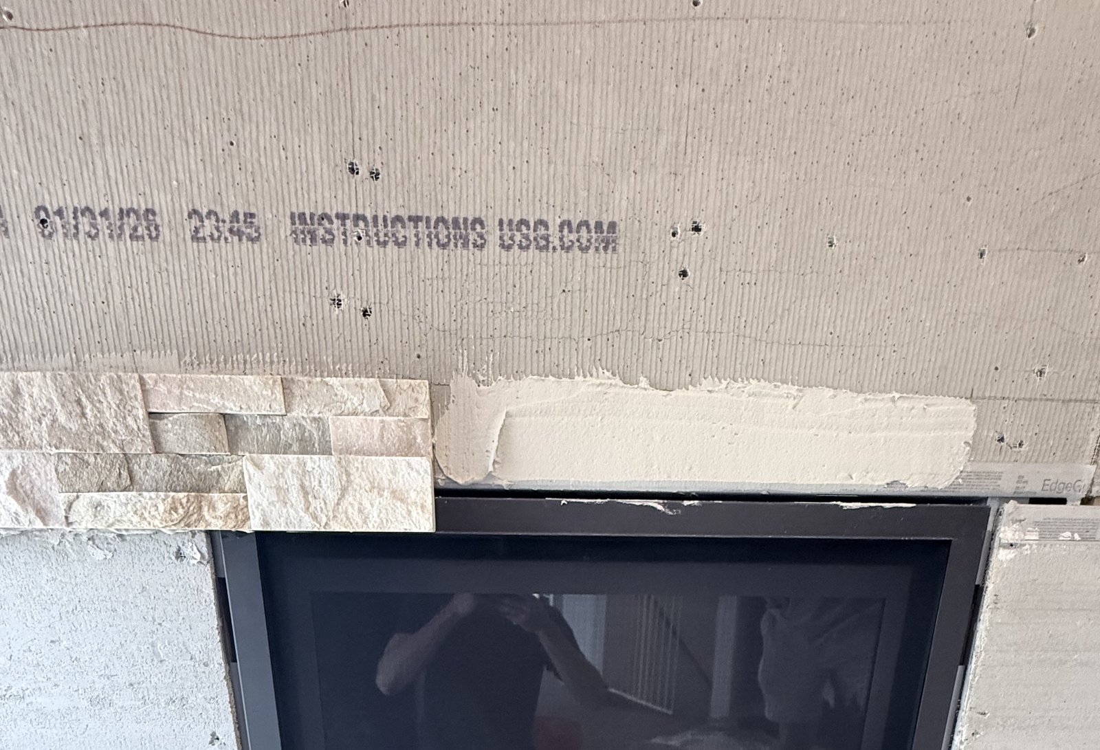 Stacked-stone fireplace surround underway on commercial jobsite.