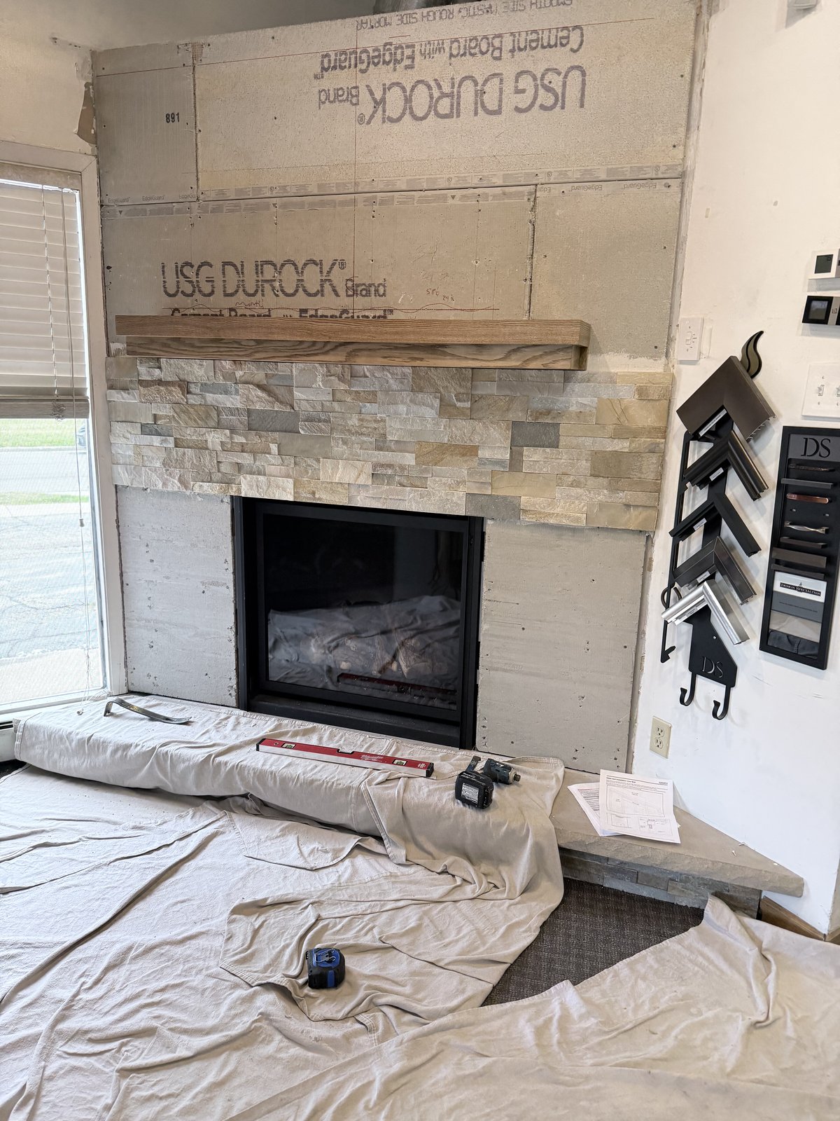 Fireplace stone surround and wood mantel in progress.