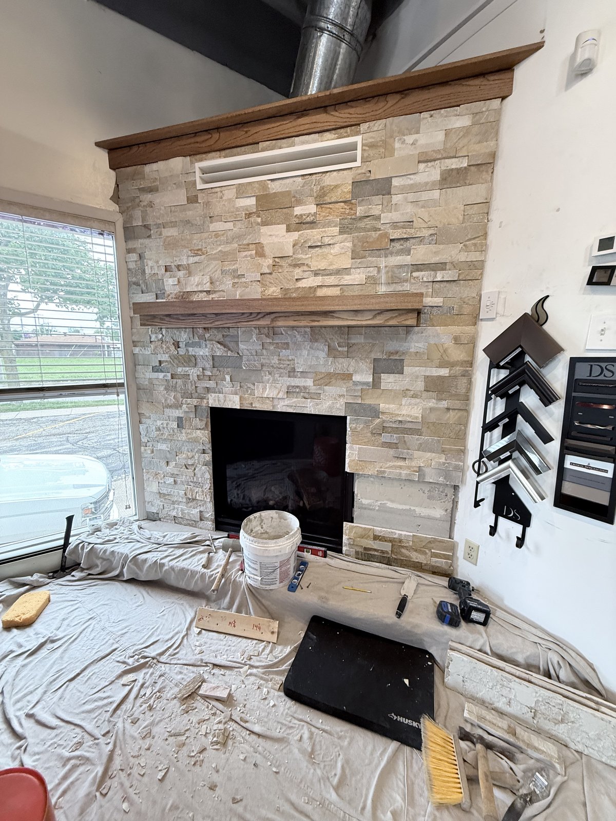 Nearly complete stacked-stone fireplace wall with wood mantel.