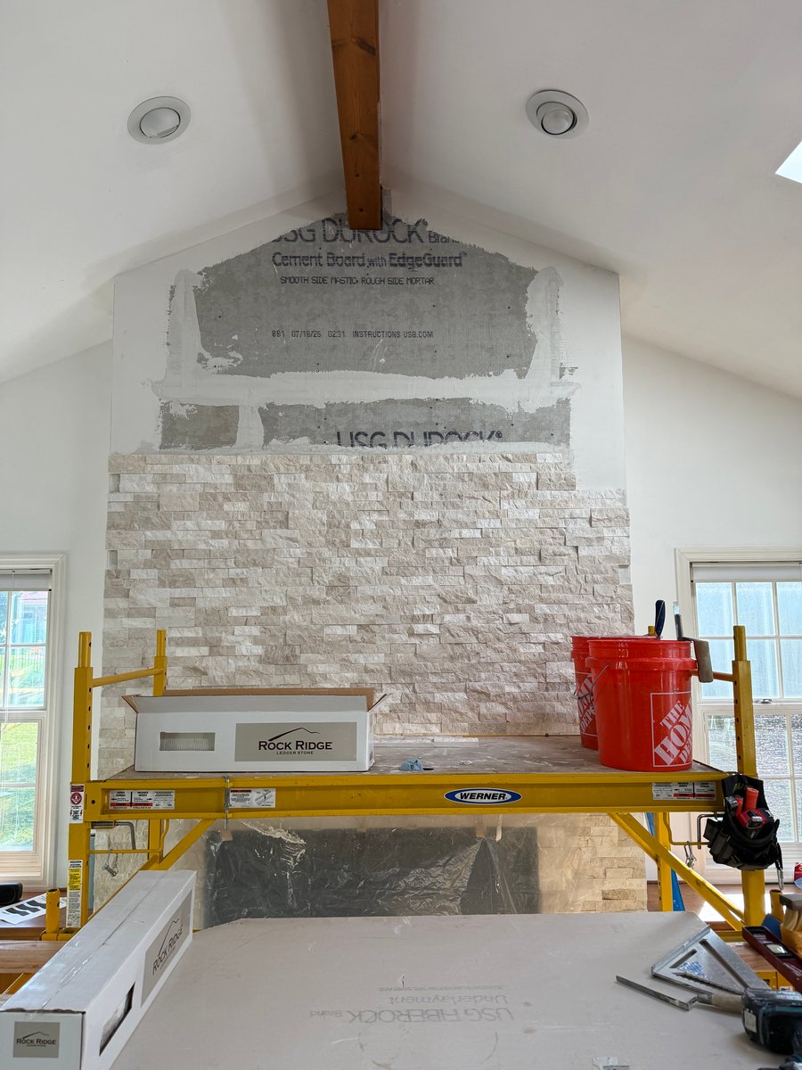 Stacked-stone fireplace wall during install.