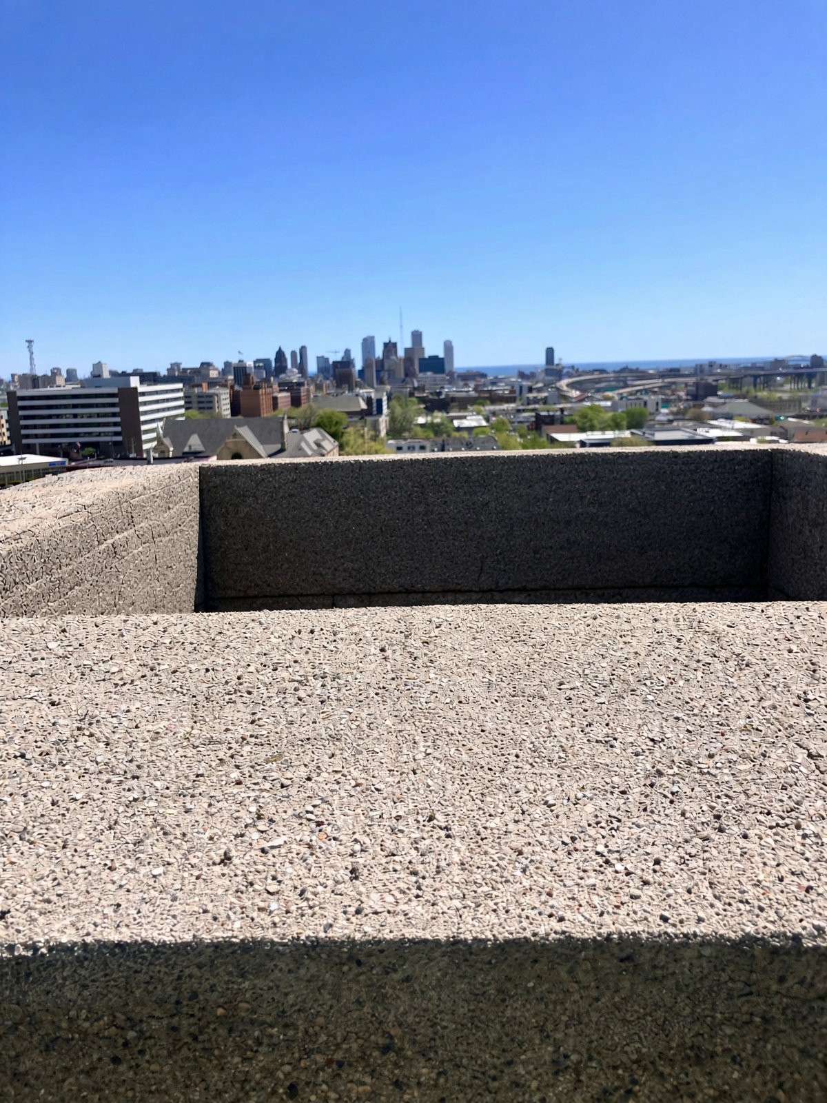 Fresh aggregate masonry parapet with downtown Milwaukee and Lake Michigan behind it.